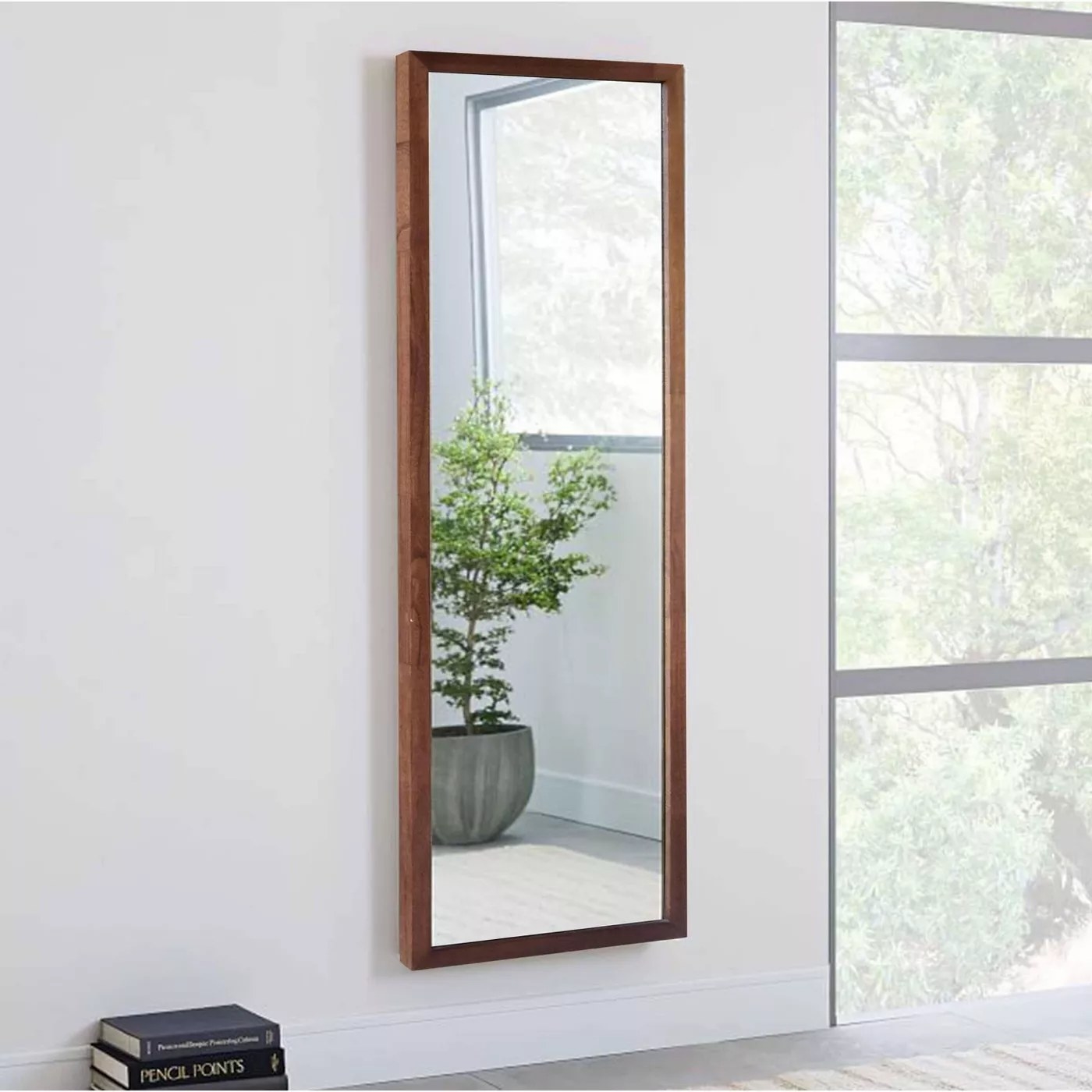 The mirror with a wooden frame hanging on a wall