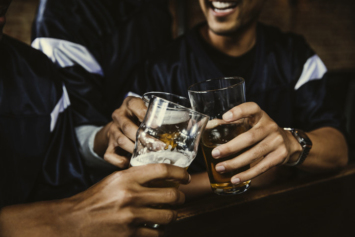 A bunch of guy friends drinking at a bar together