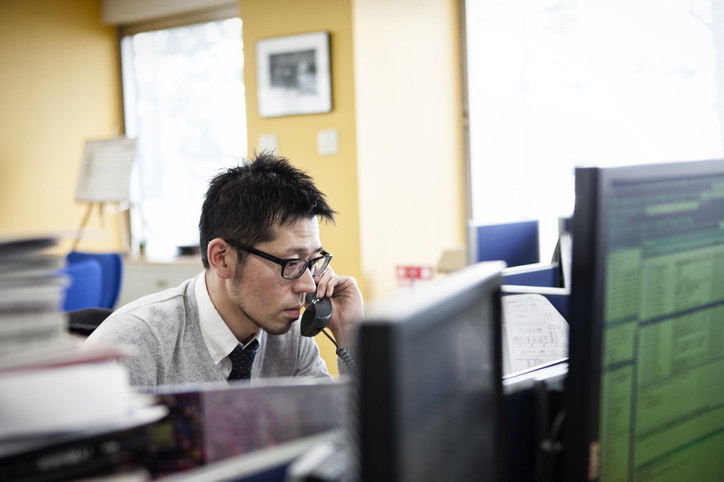 A tired, haggard looking man on phone at the office