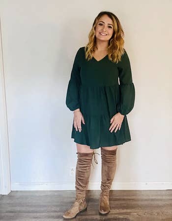 A reviewer wearing the dress in green
