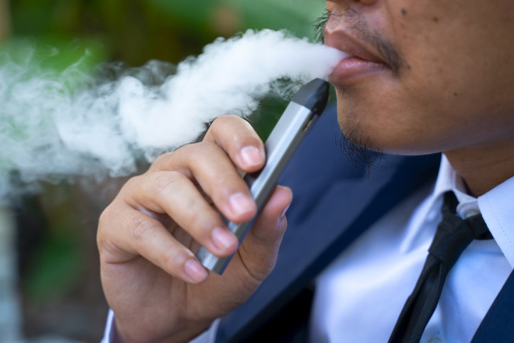 A business man smoking a vape