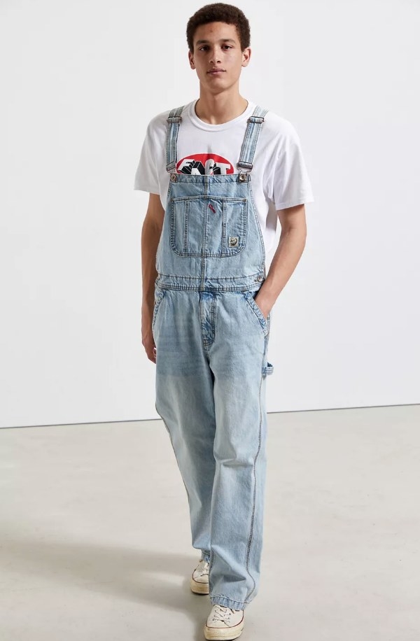 a model wearing the light wash overalls with a white t-shirt under
