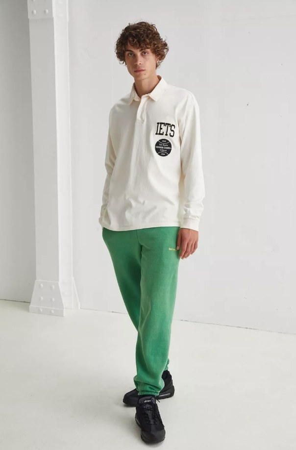 Model wearing green sweatpants with white long sleeve top