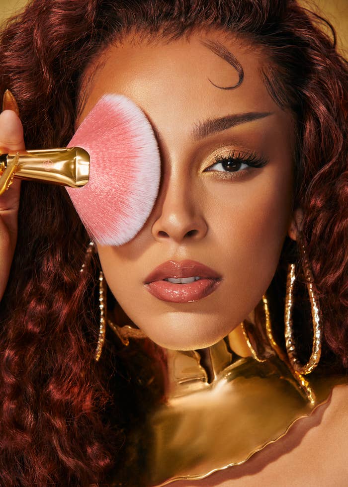 Doja Cat posing with makeup brush