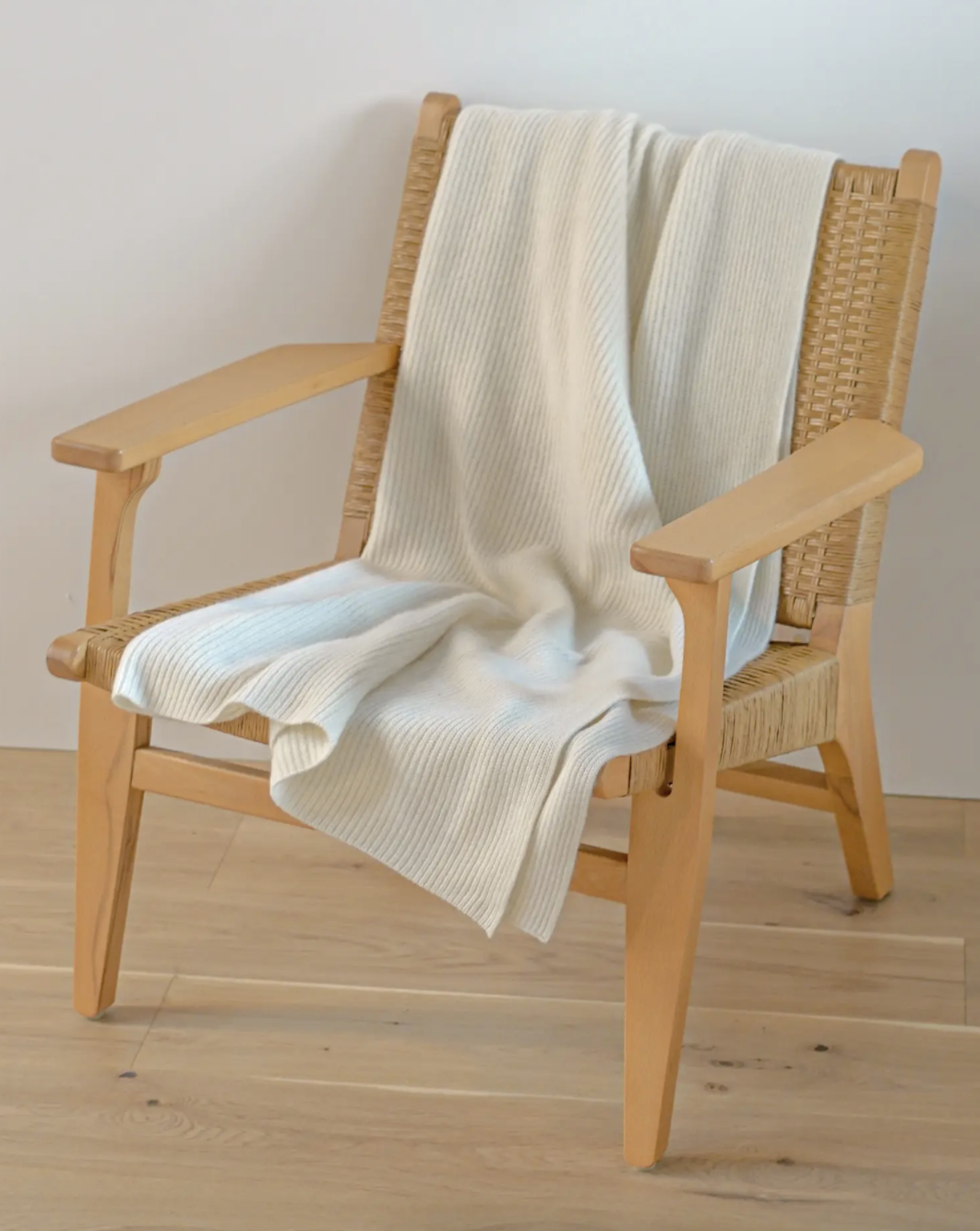 cream-colored cashmere throw on a wooden armchair