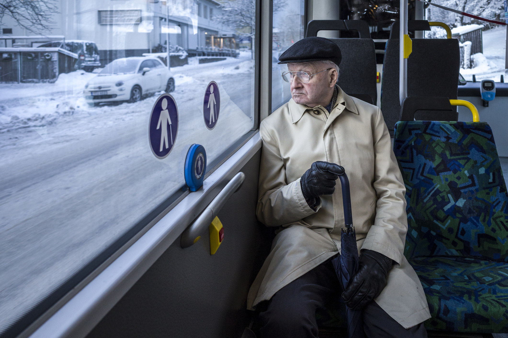 An elderly man sitting on a bus.