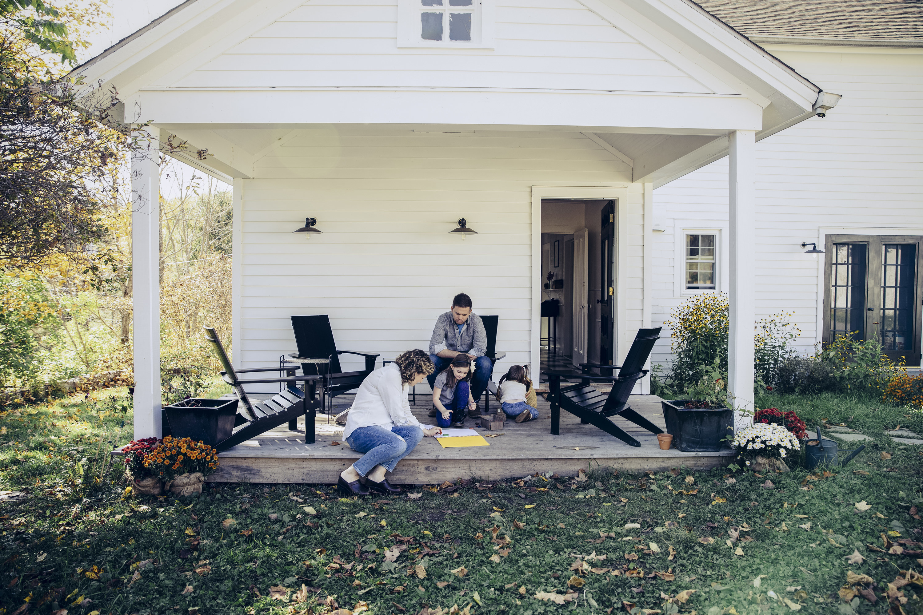 Family sitting on the porch of their rural home
