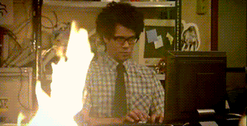 Richard Ayoade from The IT Crowd typing calming while witnessing a fire