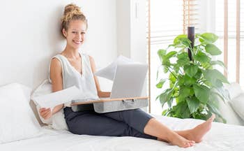 model uses the same lap desk to do work from a bed