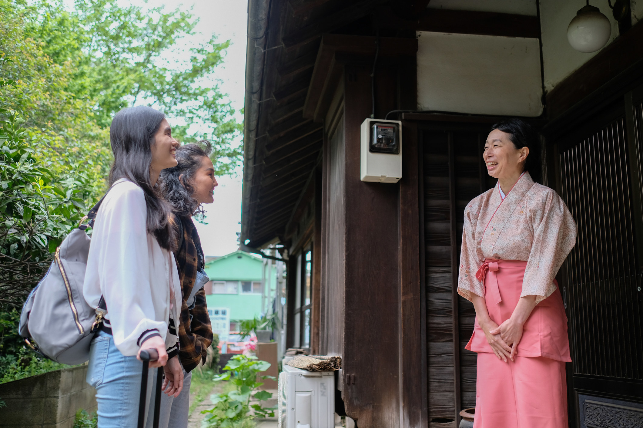 Two travelers meeting their host at a Japanese inn.