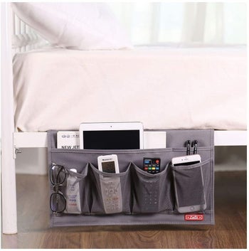 gray bedside caddy filled with electronics