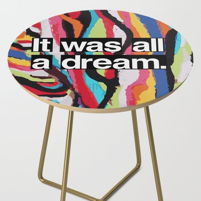 circular end table with gold legs and a colorful coogie sweater print on the top with the words &quot;It was all a dream&quot; in white on top of thep rint