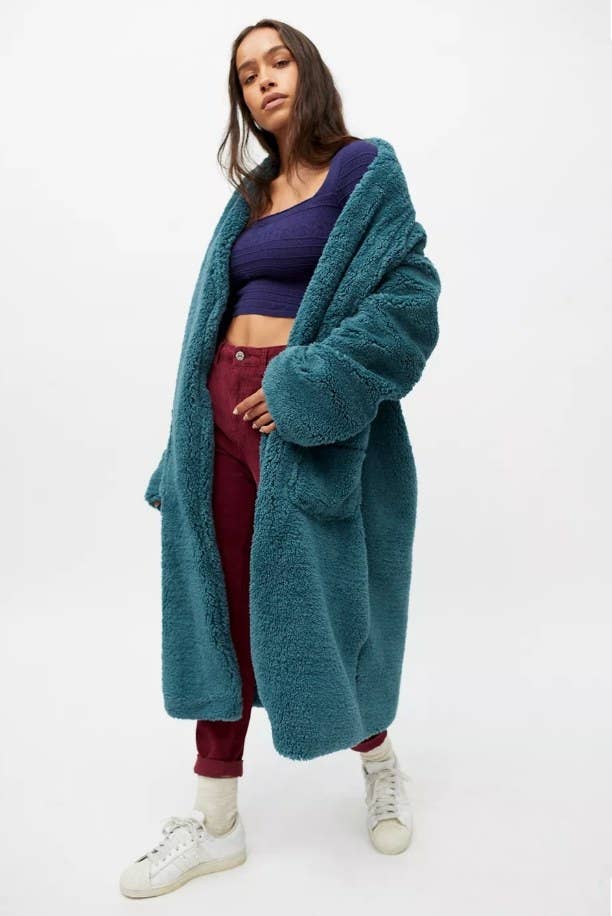 Model wearing long blue sherpa coat