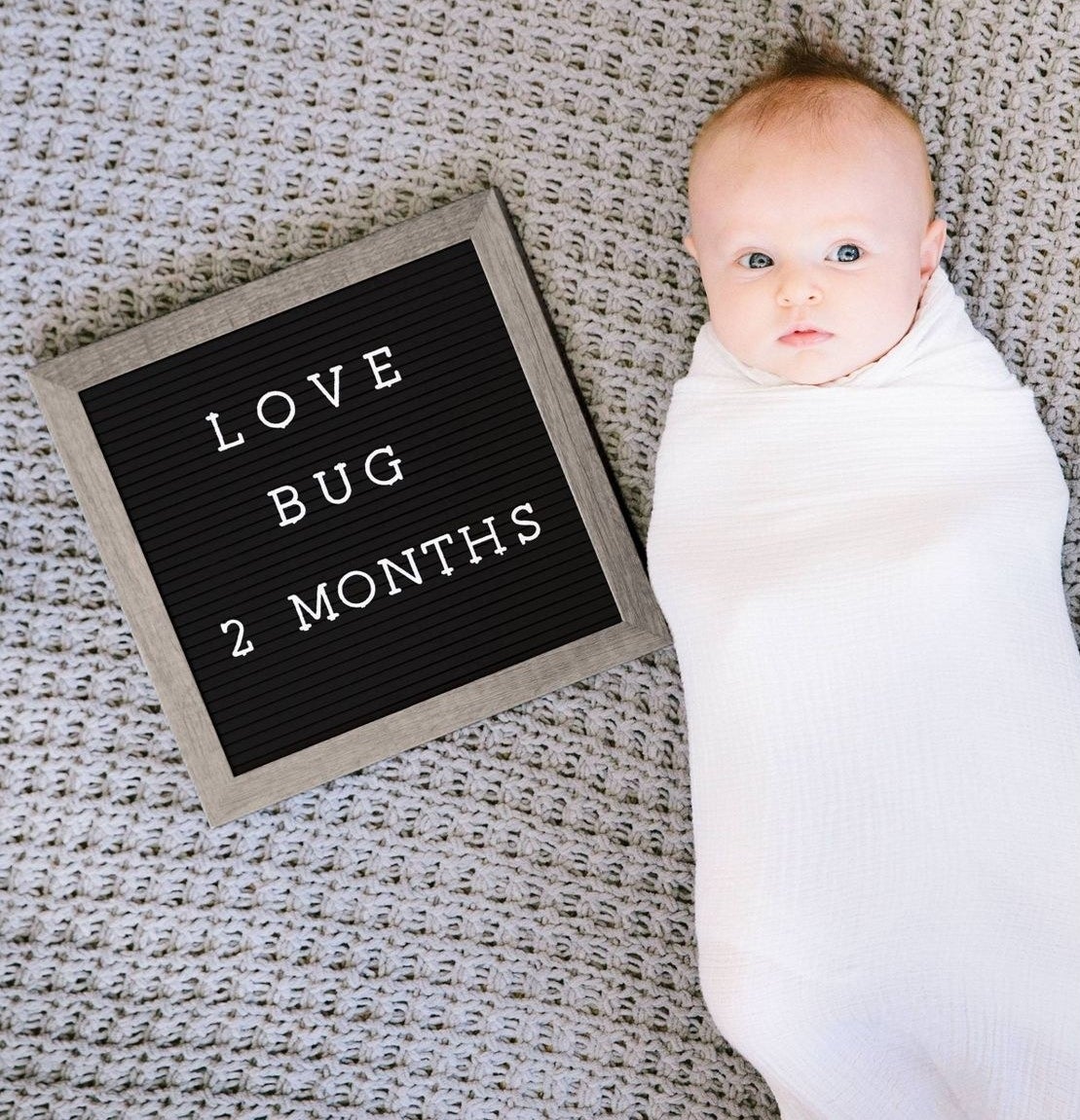 Baby next to letter board