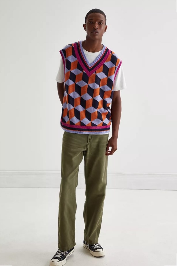 Model wearing patterned black, red, pink and blue sweater vest