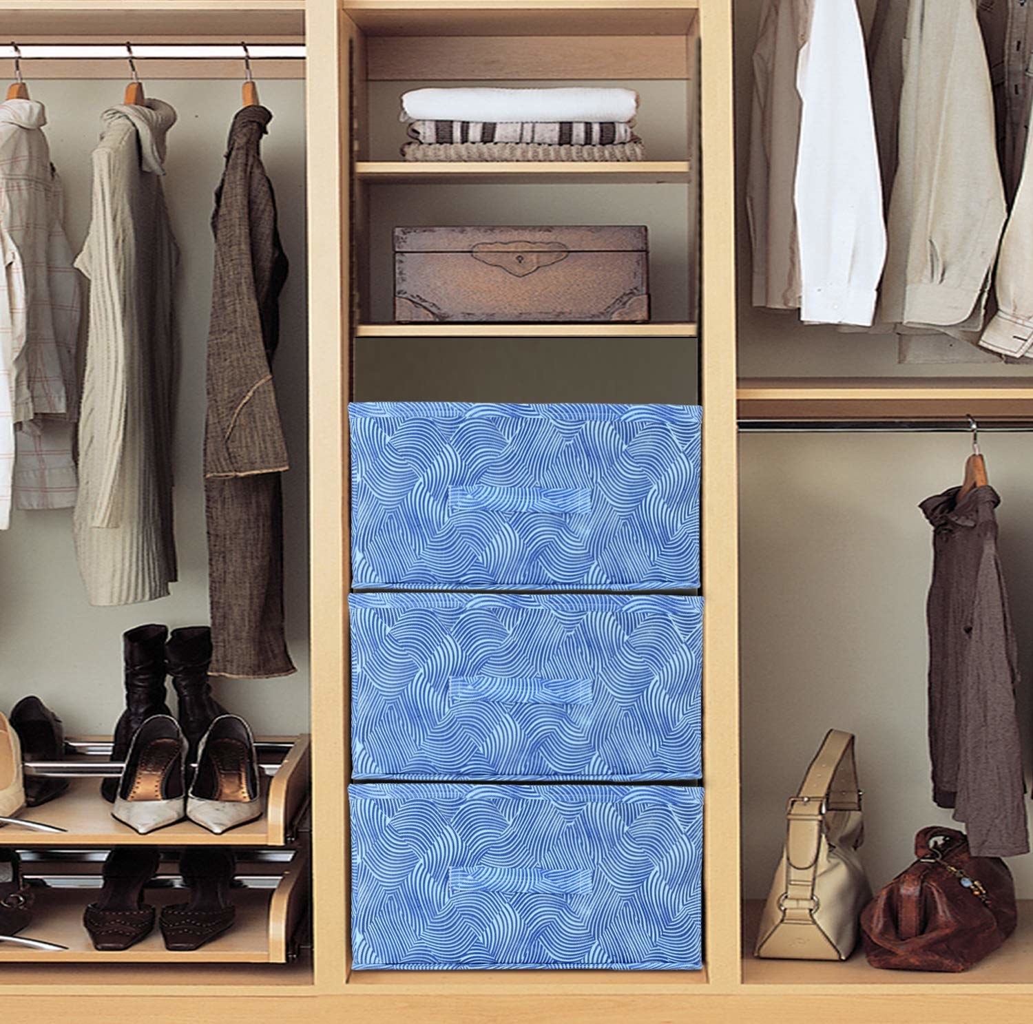 Blue storage boxes in a wardrobe next to shoes and bags