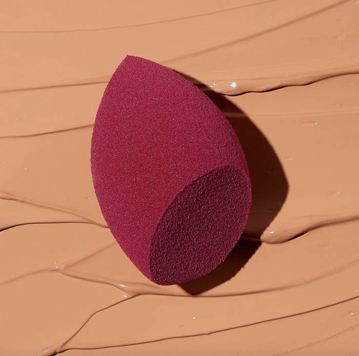 A burgundy makeup sponge