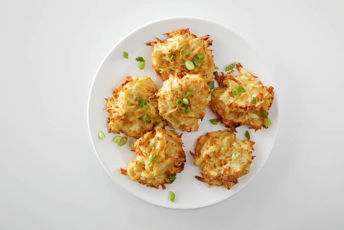 A plate of air-fried latkes garnished with green onions.