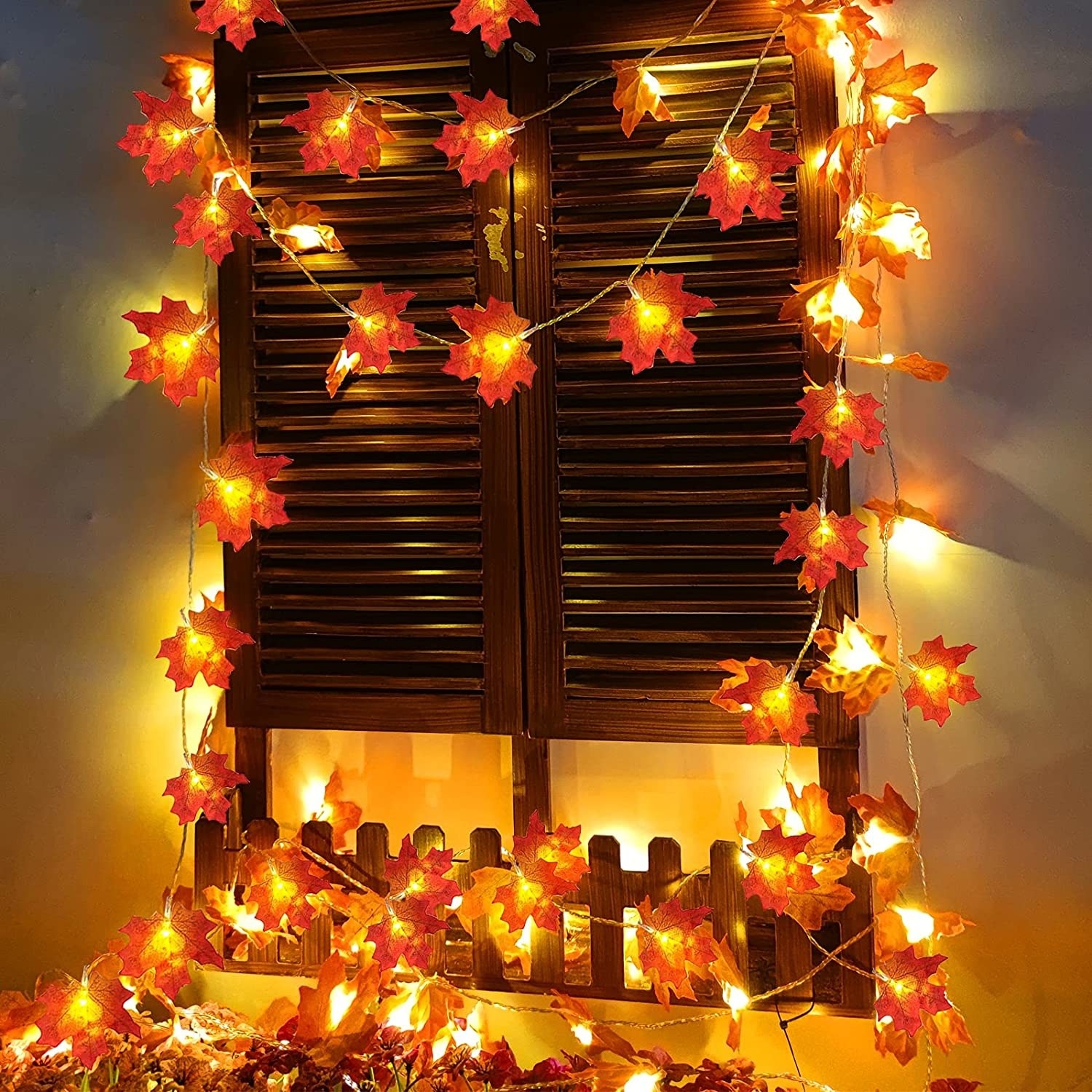 A string of lights with leaves around a window