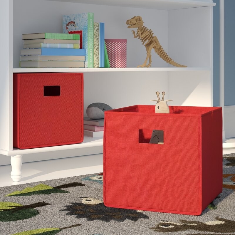the red storage bins in front of a bookshelf