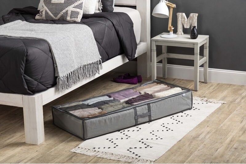 the grey storage container under a bed