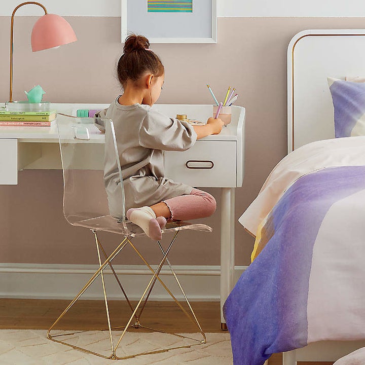 Model sitting on chair with gold legs