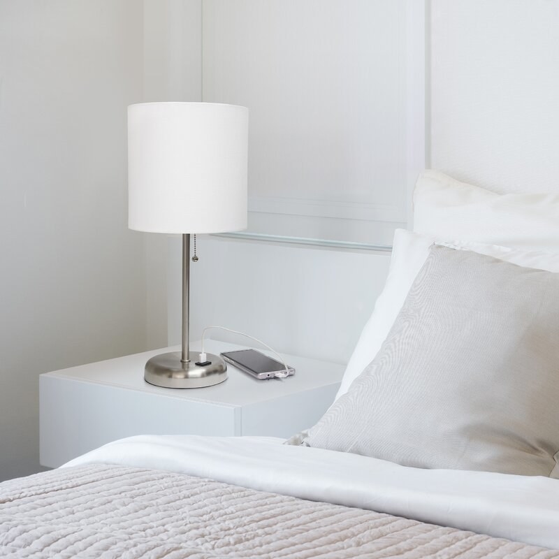 the white and silver lamp on a bedside table