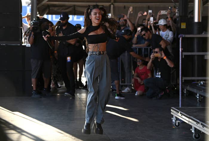 Olivia performing onstage in a crop top and pants