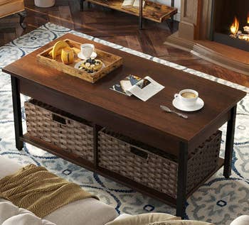 a brown coffee table with black legs with two woven storage baskets sitting in the storage area underneath