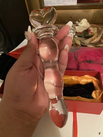 Reviewer holding glass wand with heart-shaped base