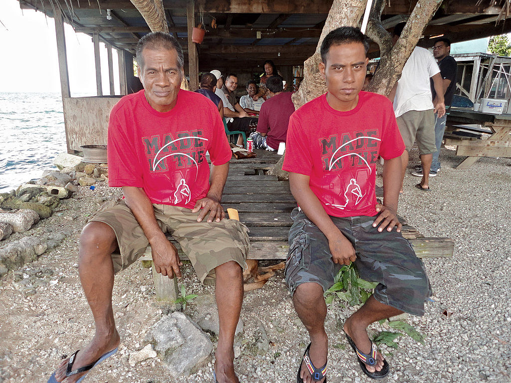 The two Kiribati fishermen sitting on a pier together