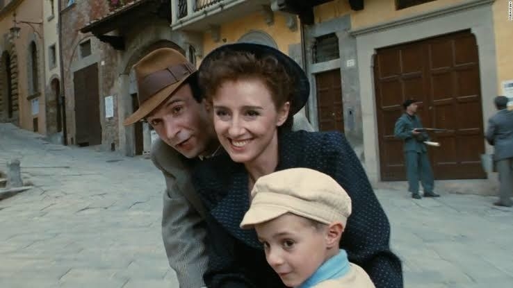 A still of Roberto Benigni, Nicoletta Braschi, and Giorgio Cantarini from the movie.