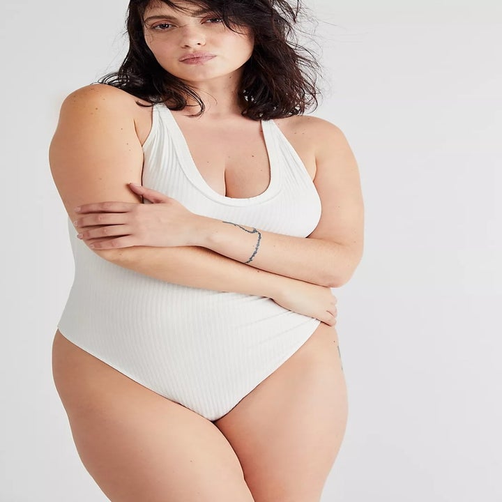model wearing the body suit in white with arms crossed over the stomach