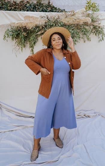 model wearing the tan jacket over a lilac jumpsuit