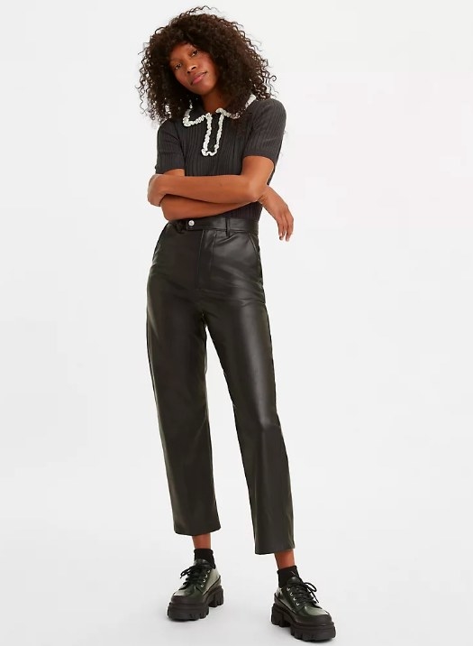 Model wearing the black ankle-cut faux leather pants