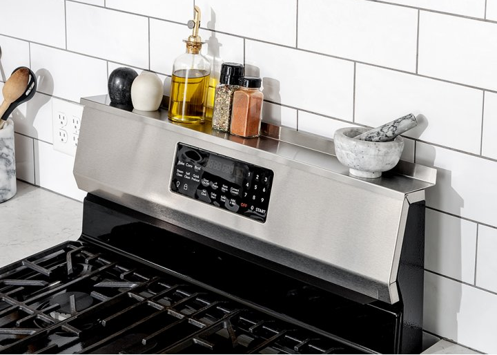 a stove with the shelf along the top and spices sitting on it