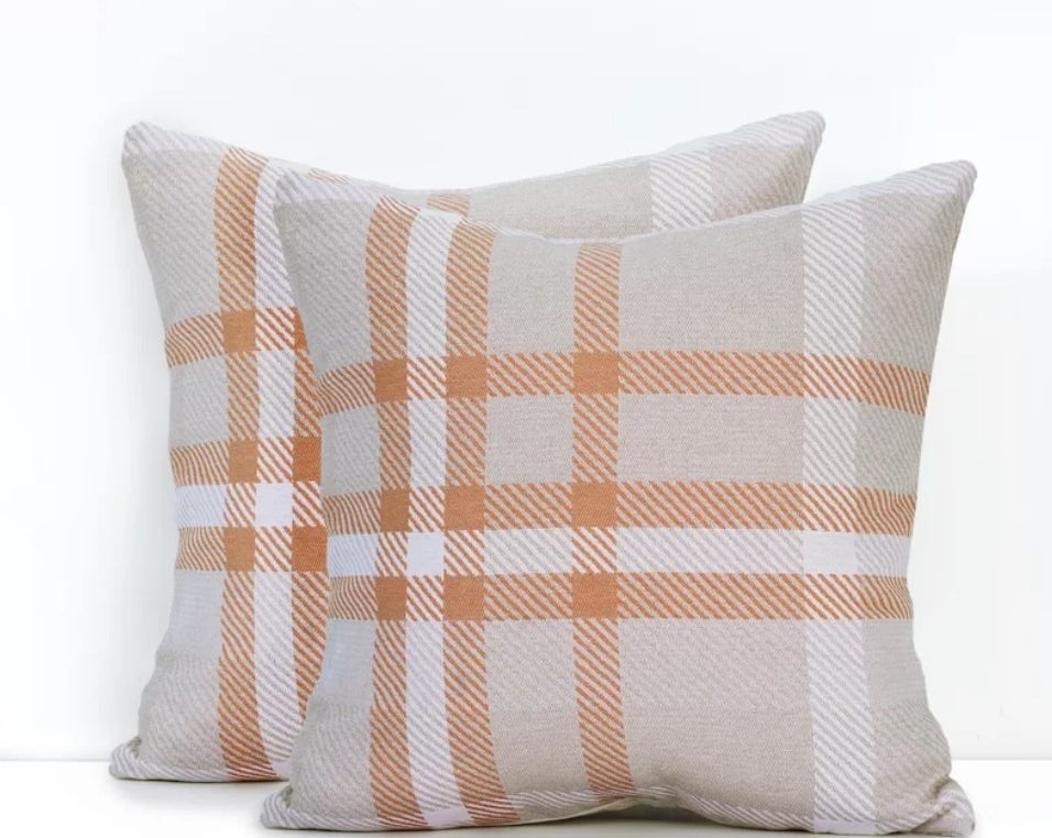 A set of two orange/beige plaid throw pillows