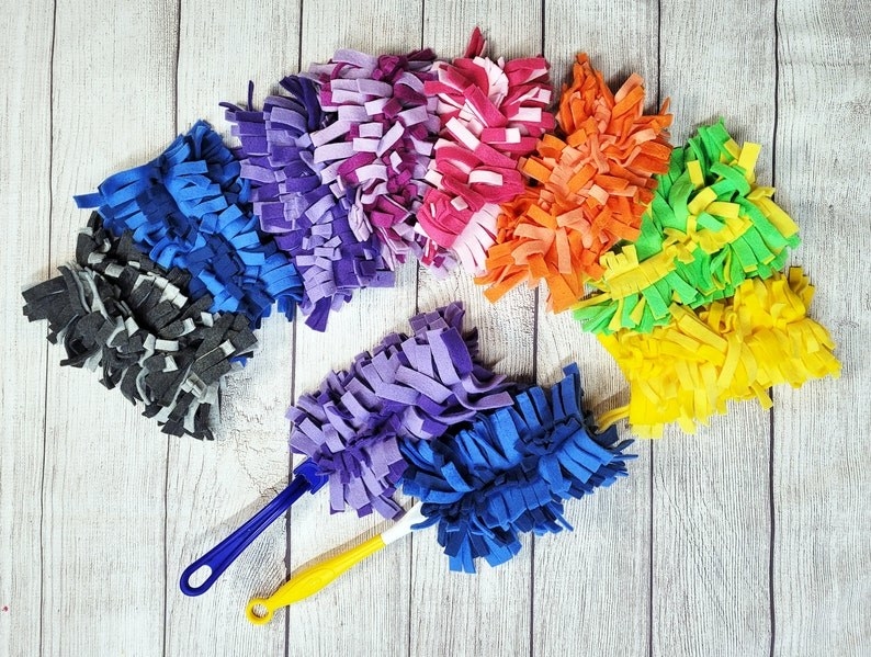 colorful reusable duster heads arranged in a circle on a wooden surface