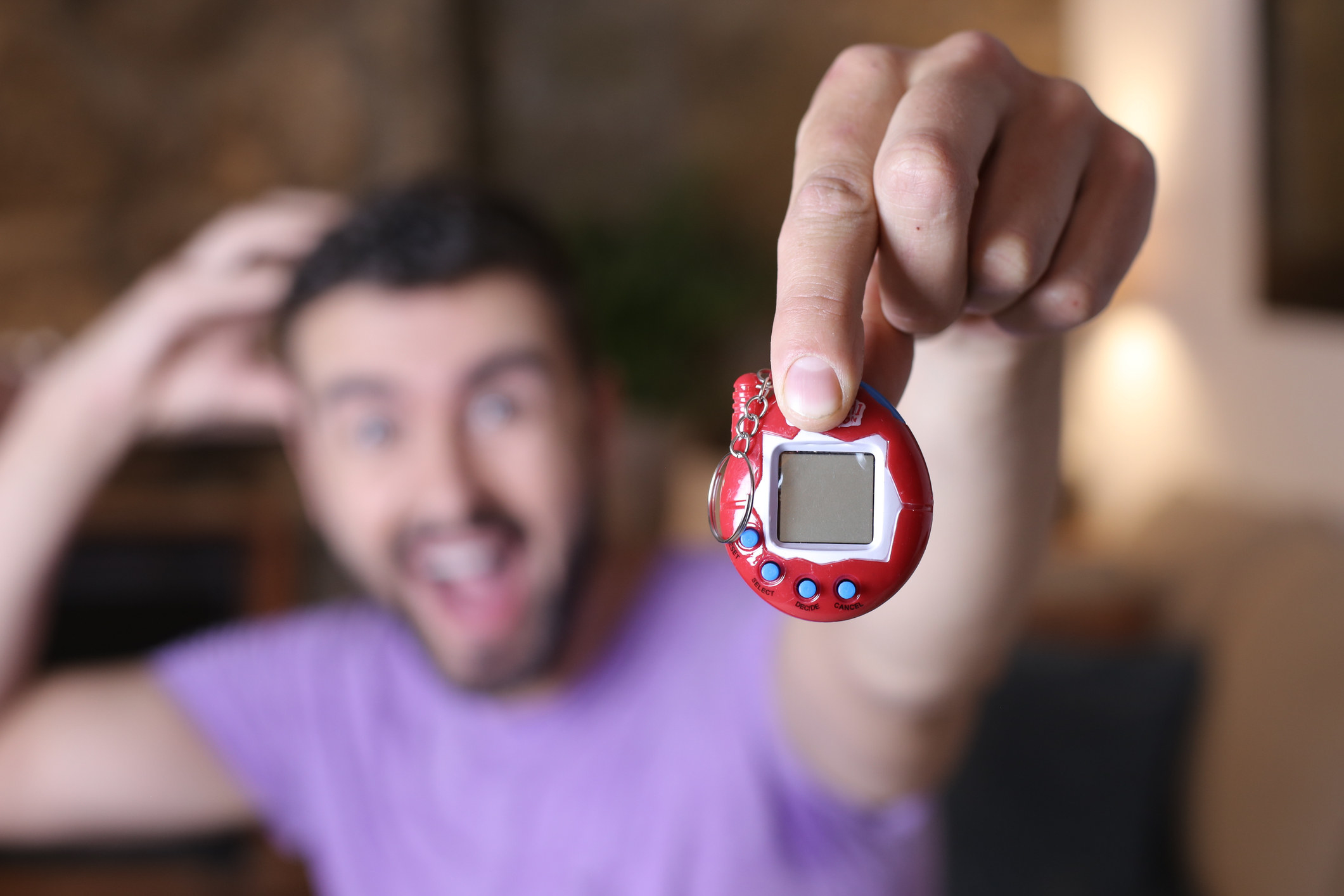 a man holding a tamagochi