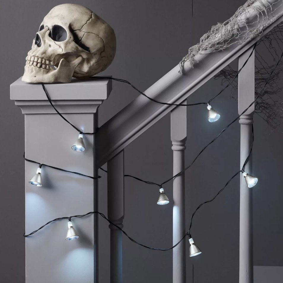 Strobe lights wrapped around staircase with decorative skull on banister