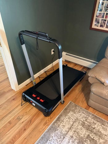 same reviewer's photo of the unfolded treadmill in the corner of room