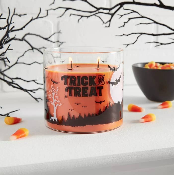 Orange candle with &quot;Trick or treat&quot; on container