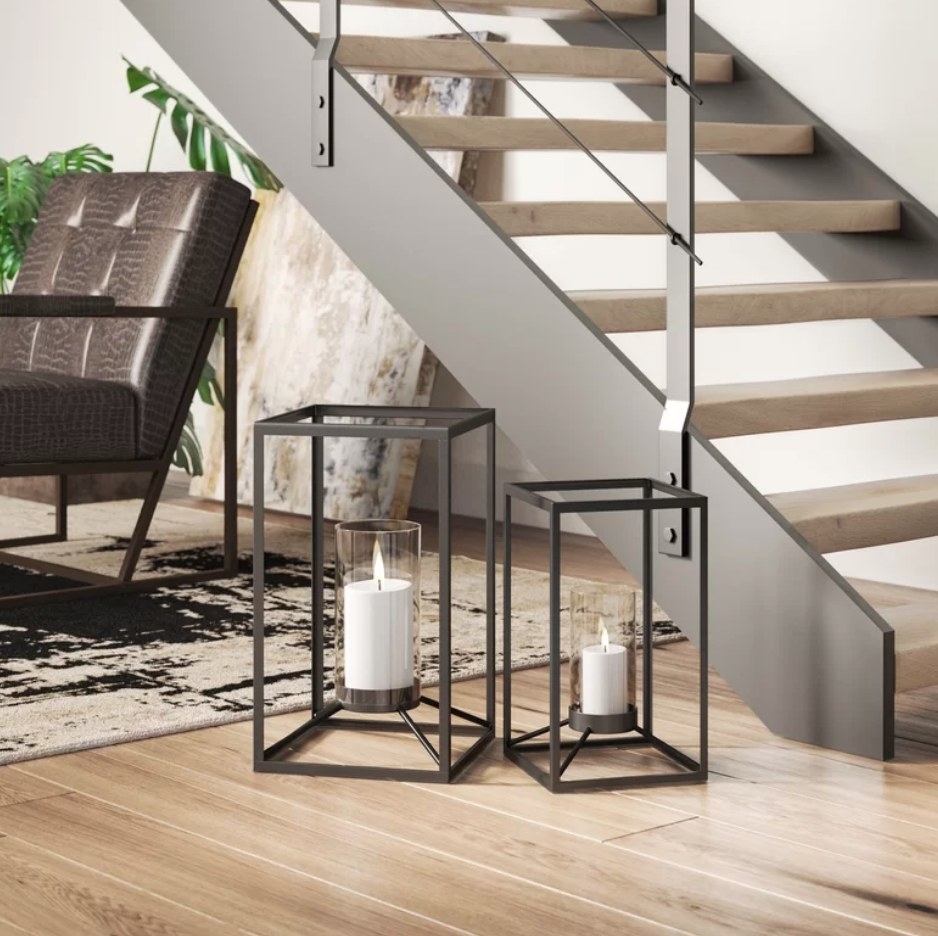 A set of 2 rectangular, metal lanterns with candle pillar holders inside