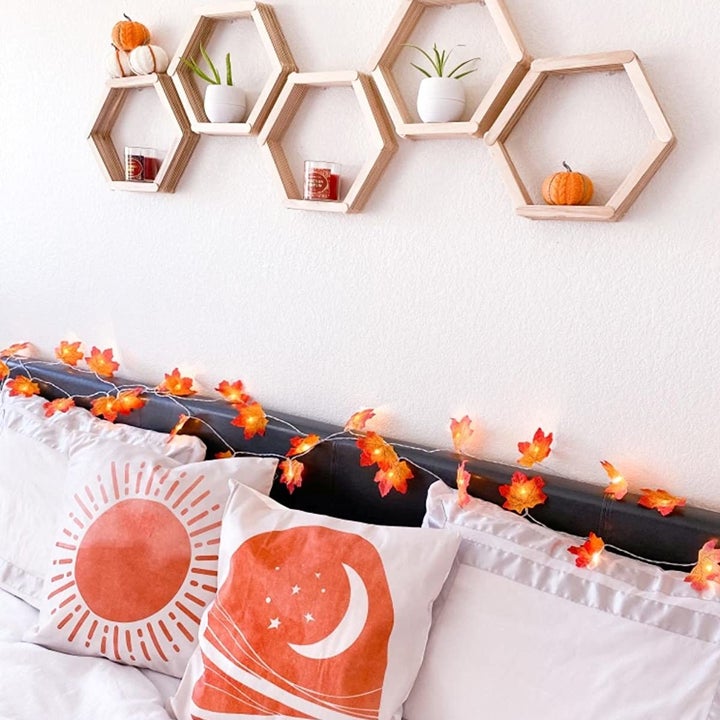 Reviewer photo of the garland with the lights on, on their bed