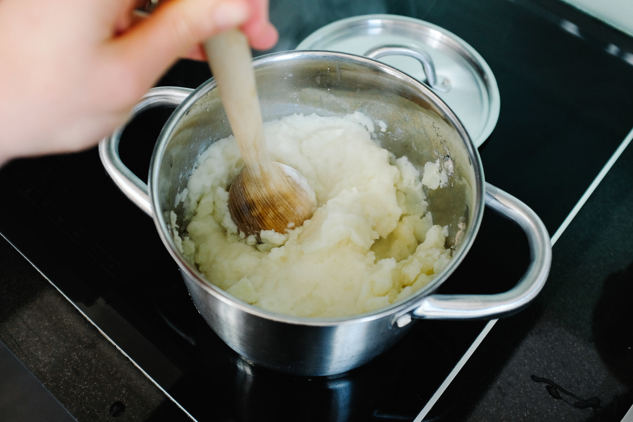 Mashing potatoes in a pot.