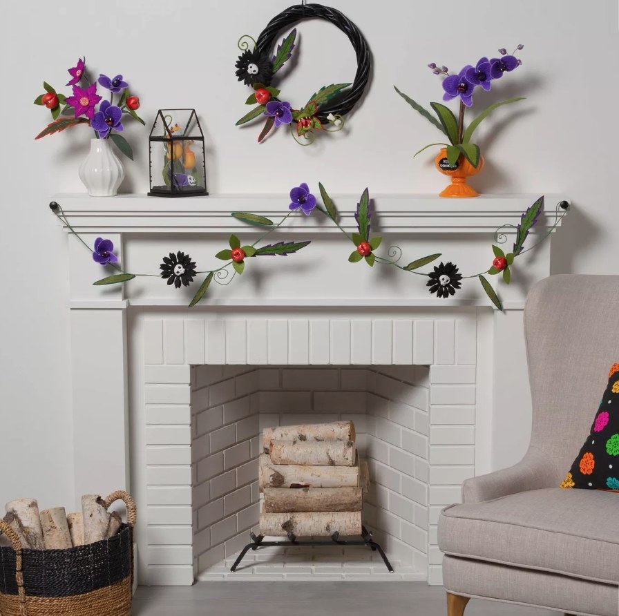 Purple, black, red and green flower garland hanging from mantle