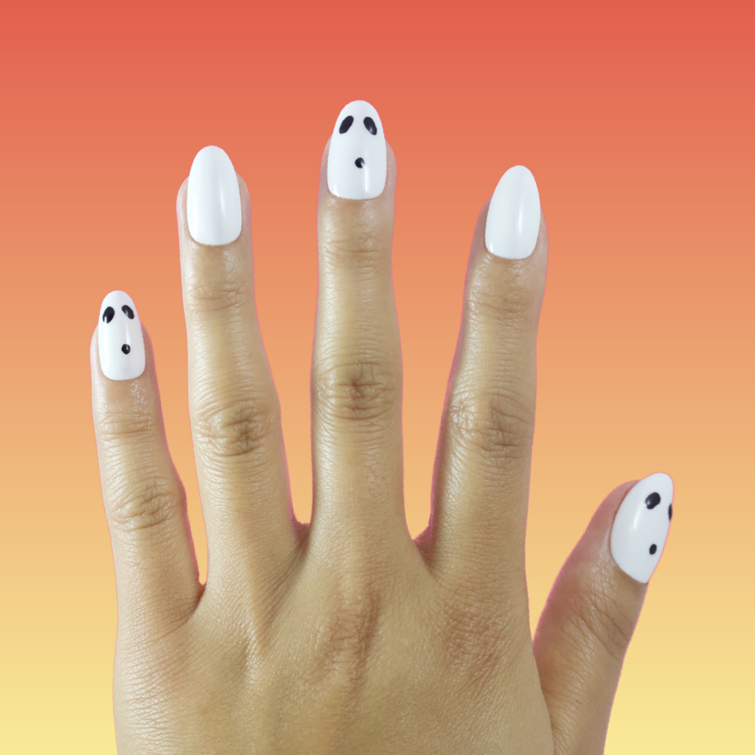 Hand with white nails with ghost faces.