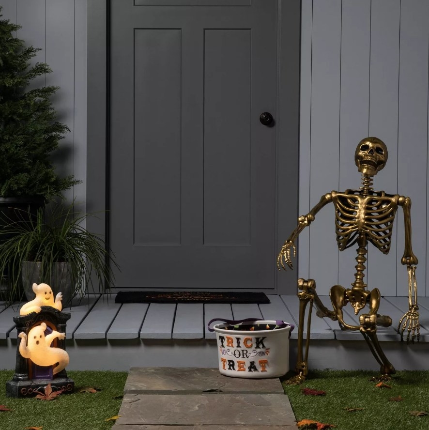 Golden skeleton sitting on front porch