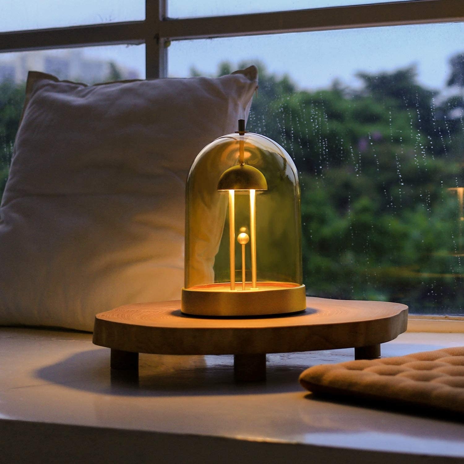The lamp on a table surrounded by throw cushions