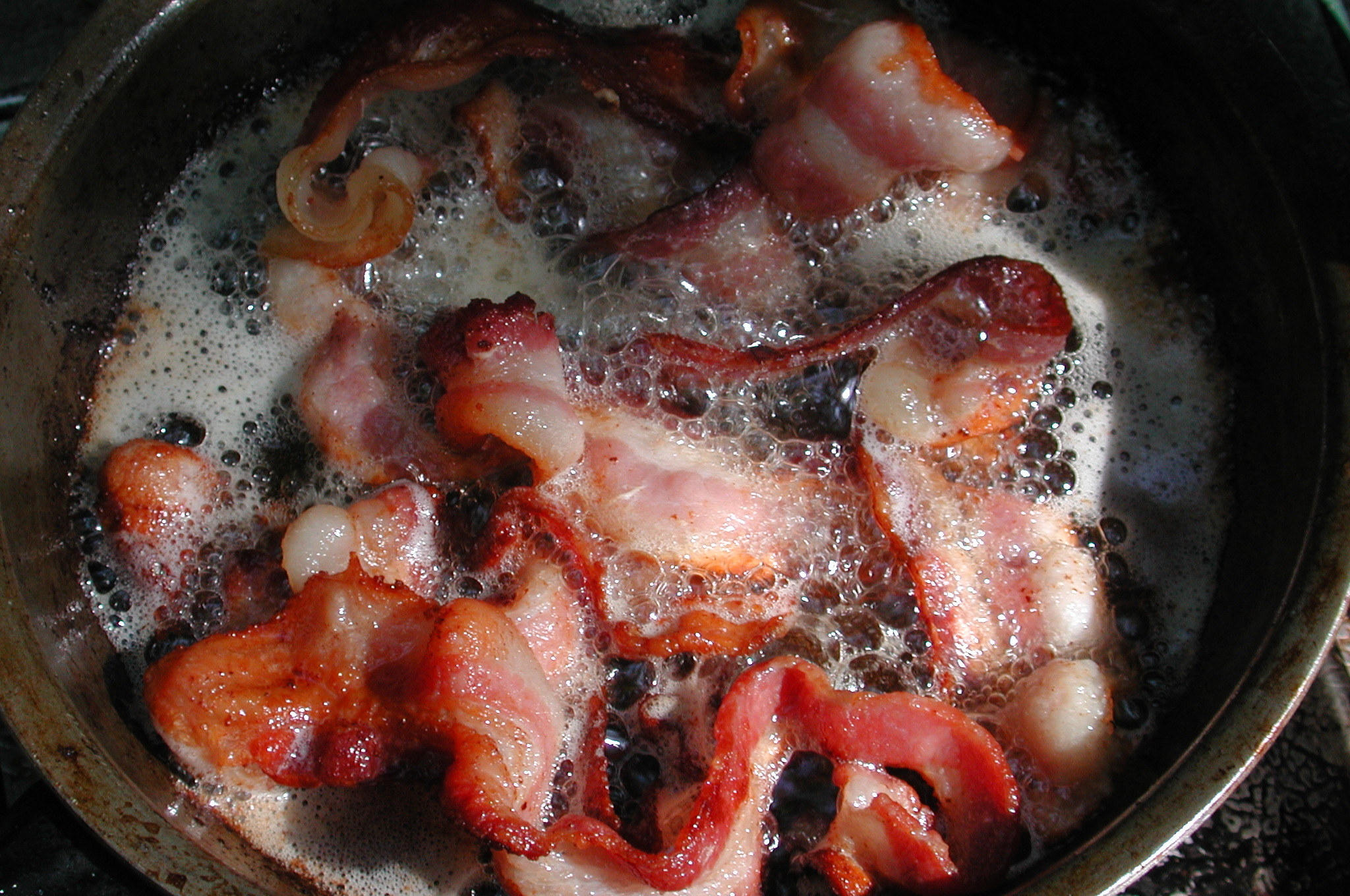 Bacon sizzling in its fat.